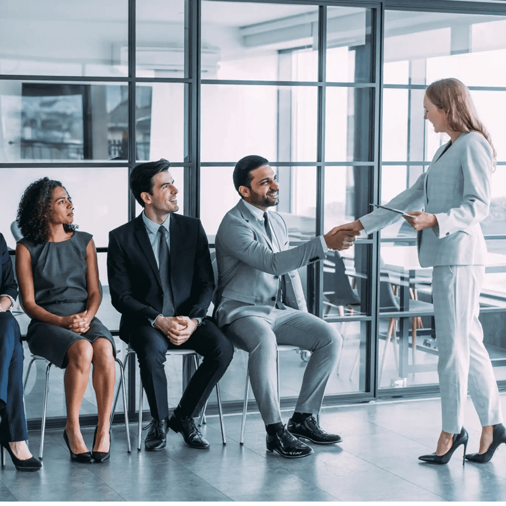 Businesspeople shaking hands in a modern office setting.
