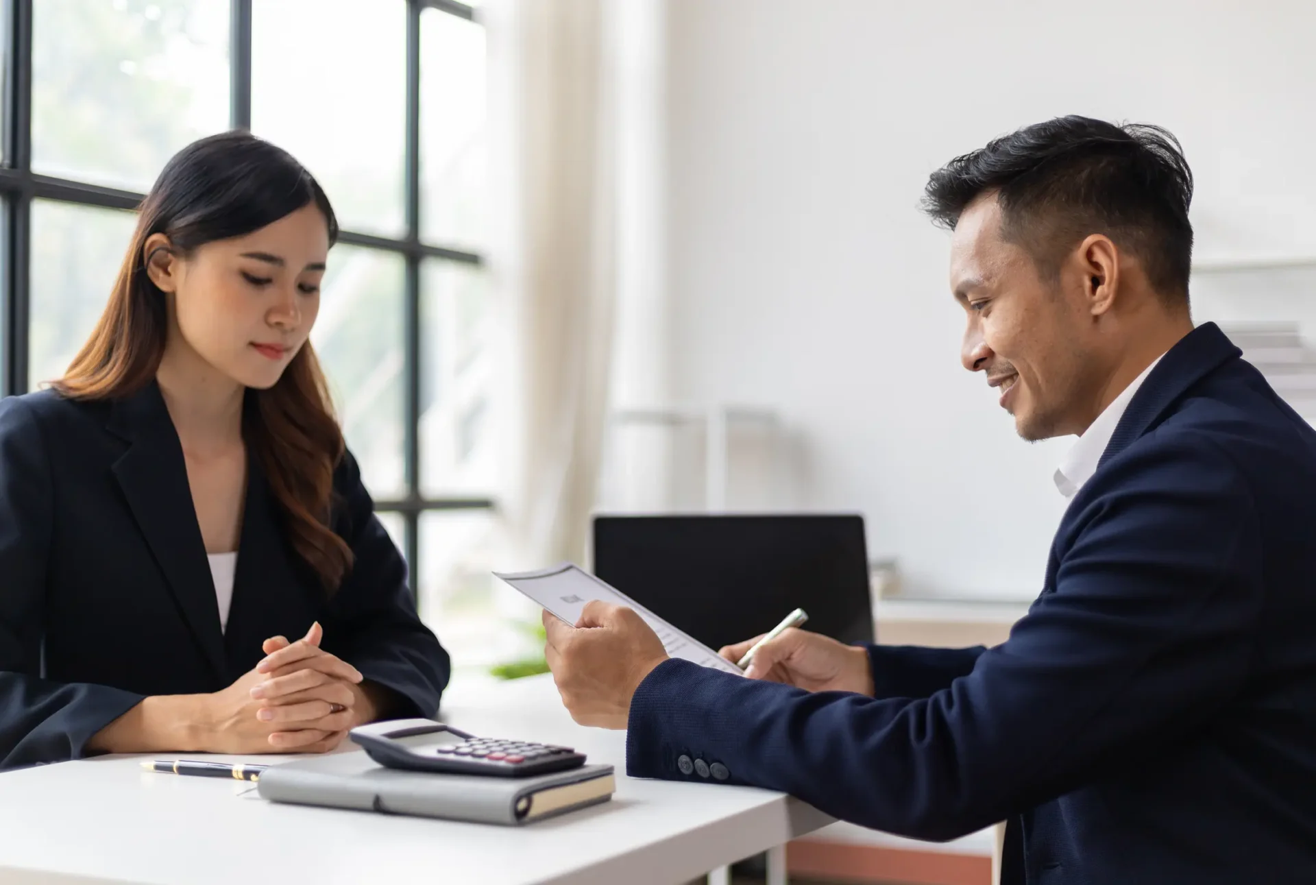 Man and woman discussing documents at desk