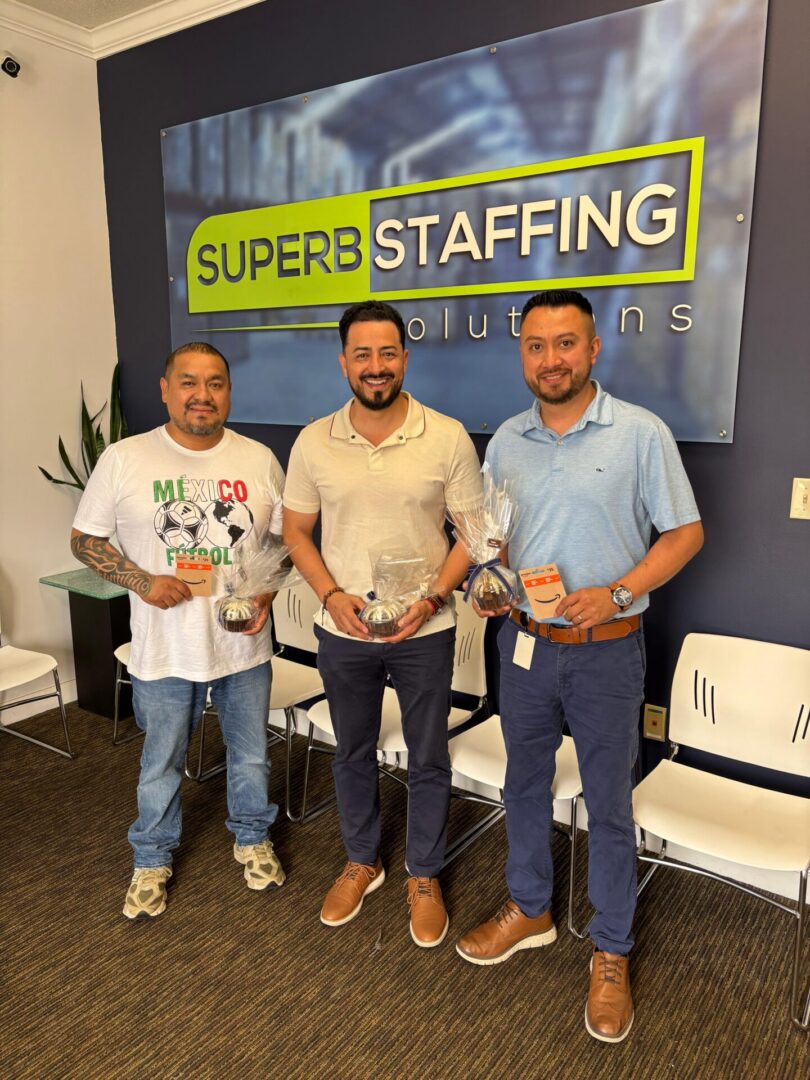 Three men in front of Superb Staffing sign
