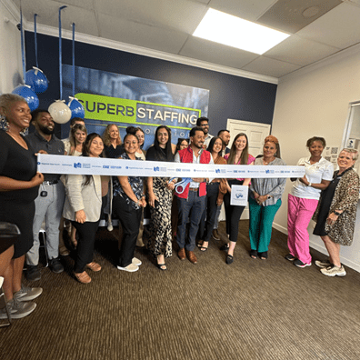 Group celebration with ribbon cutting at an event.