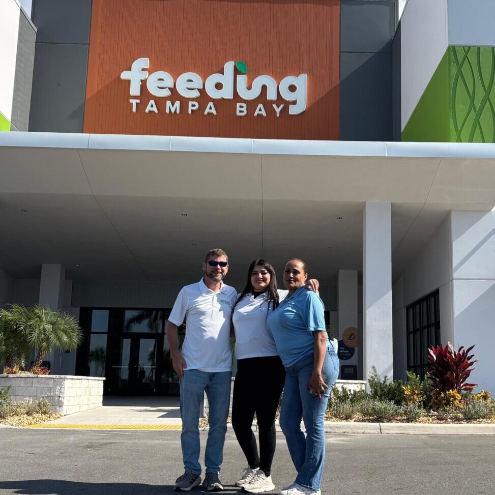 Smiling trio outside Feeding Tampa Bay center